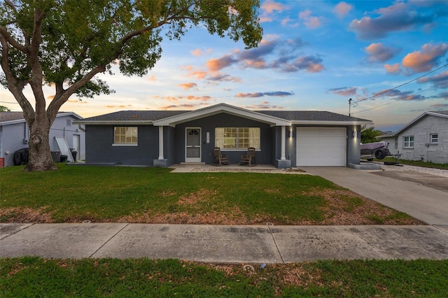 ranch-style home featuring stucco siding, a lawn, concrete driveway, and an attached garage