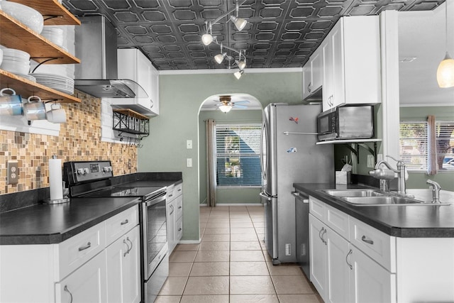 kitchen featuring open shelves, wall chimney range hood, dark countertops, and appliances with stainless steel finishes