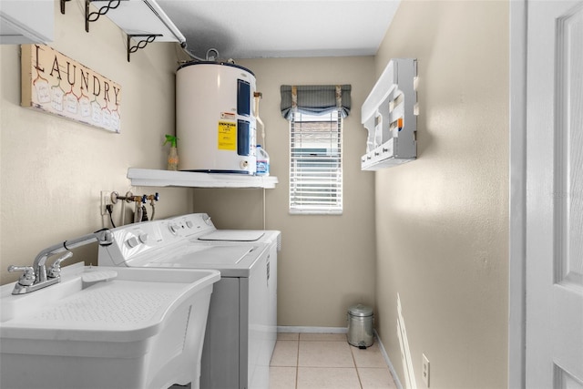 washroom with electric water heater, washing machine and dryer, light tile patterned floors, laundry area, and a sink