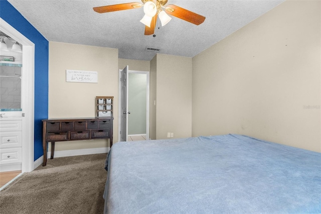 carpeted bedroom with ceiling fan, visible vents, and a textured ceiling