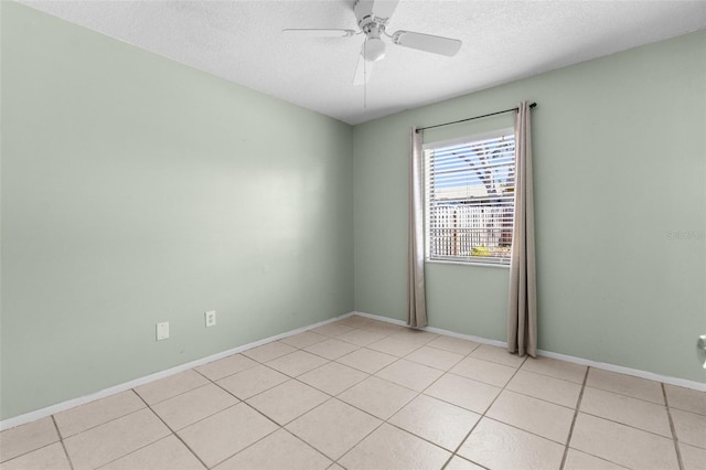 empty room featuring baseboards, light tile patterned floors, a textured ceiling, and a ceiling fan