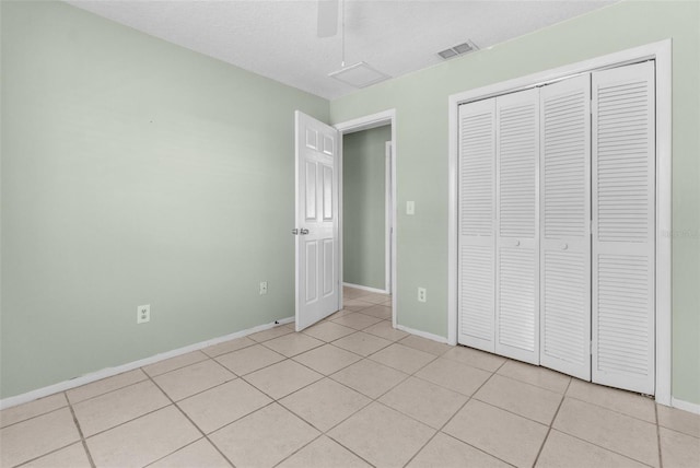 unfurnished bedroom with visible vents, baseboards, light tile patterned floors, a closet, and a ceiling fan