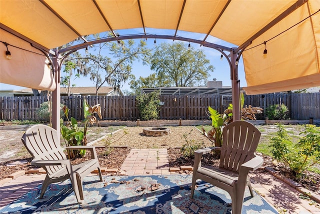 view of patio with an outdoor fire pit and a fenced backyard