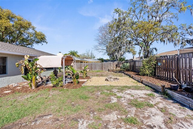 view of yard featuring a garden and a fenced backyard