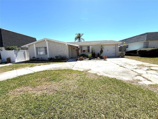 view of front of property featuring fence, driveway, roof with shingles, a front lawn, and a garage