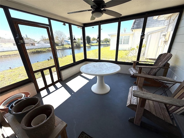 sunroom with a water view and a ceiling fan