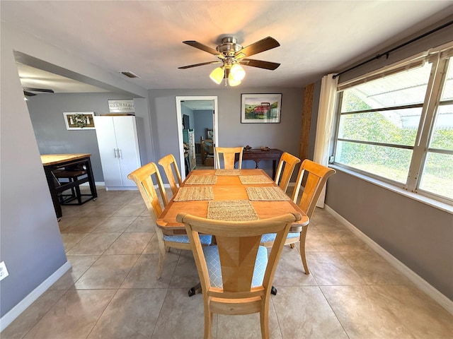 dining space featuring light tile patterned floors, visible vents, ceiling fan, and baseboards