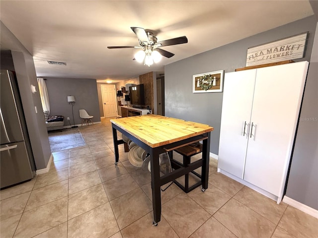 dining room with a ceiling fan, light tile patterned floors, visible vents, and baseboards