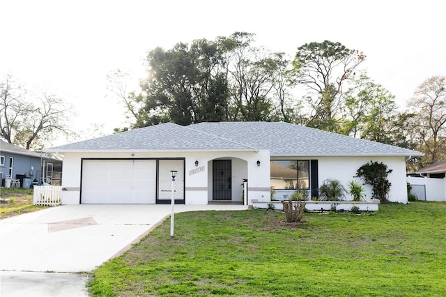 ranch-style home featuring fence, concrete driveway, a front yard, stucco siding, and a garage