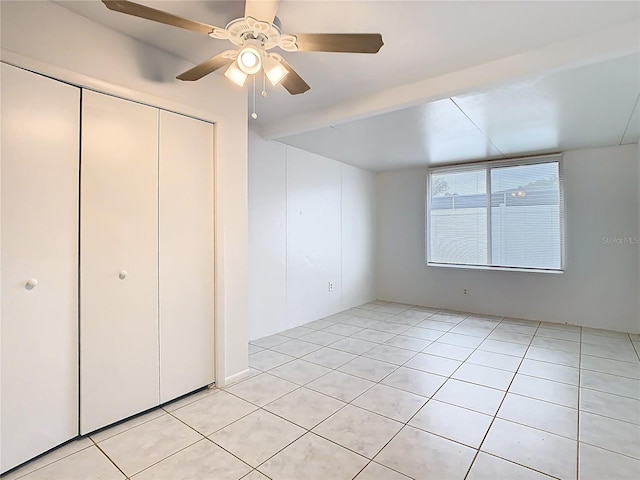 unfurnished bedroom with a closet, ceiling fan, and light tile patterned flooring