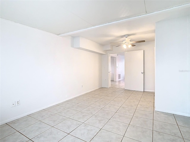 spare room featuring light tile patterned floors, baseboards, visible vents, and ceiling fan