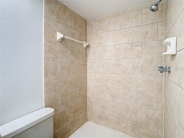 full bathroom featuring toilet and a tile shower