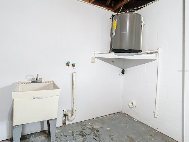 clothes washing area featuring a sink and water heater