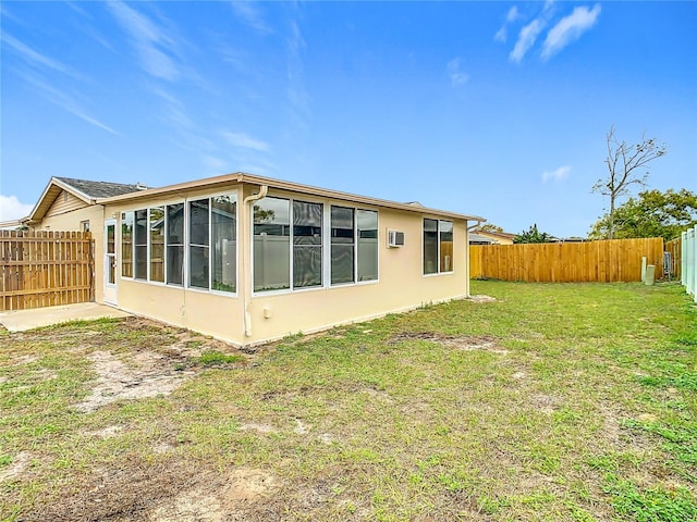 back of property with a yard, a fenced backyard, and a sunroom