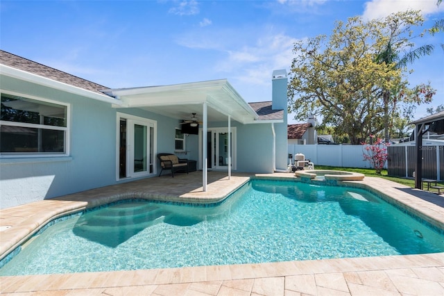 view of pool with a patio, fence, a pool with connected hot tub, ceiling fan, and french doors