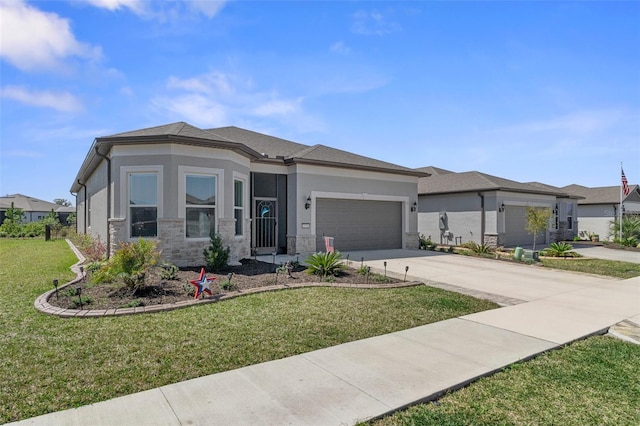 prairie-style home featuring a front lawn, stucco siding, a garage, stone siding, and driveway