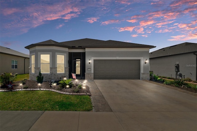 view of front facade with an attached garage, stone siding, driveway, and stucco siding