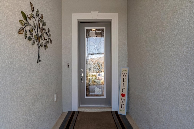 entrance to property with stucco siding