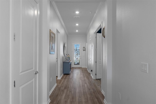 hall featuring visible vents, crown molding, baseboards, recessed lighting, and wood finished floors