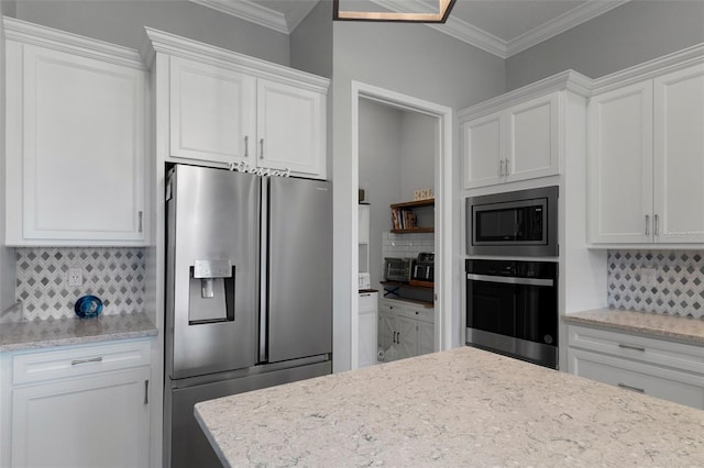 kitchen featuring white cabinetry, decorative backsplash, appliances with stainless steel finishes, and ornamental molding