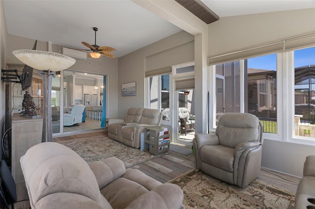 living room featuring plenty of natural light, a wall mounted AC, ceiling fan, and wood finished floors