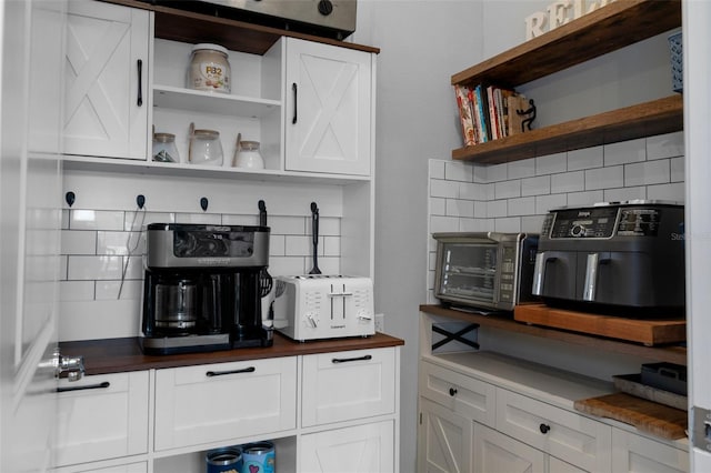 kitchen featuring open shelves, backsplash, butcher block counters, and white cabinetry