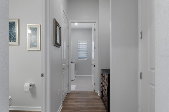 hallway featuring baseboards and dark wood-style floors