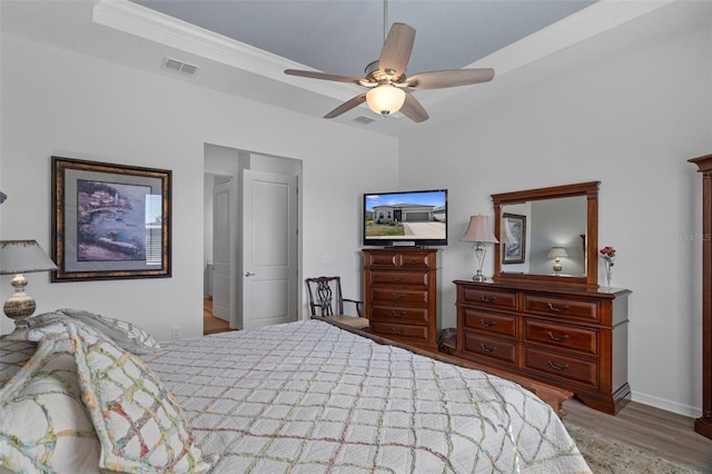 bedroom with visible vents, baseboards, ceiling fan, and wood finished floors