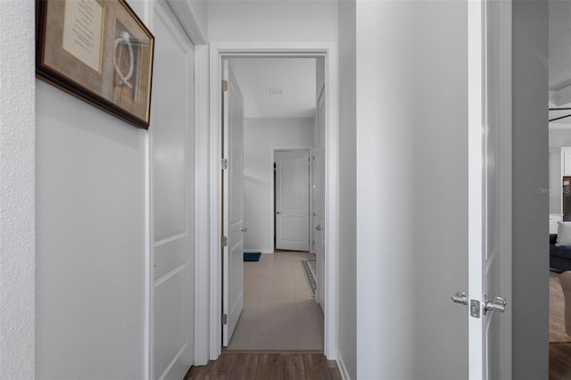 hallway featuring baseboards and wood finished floors