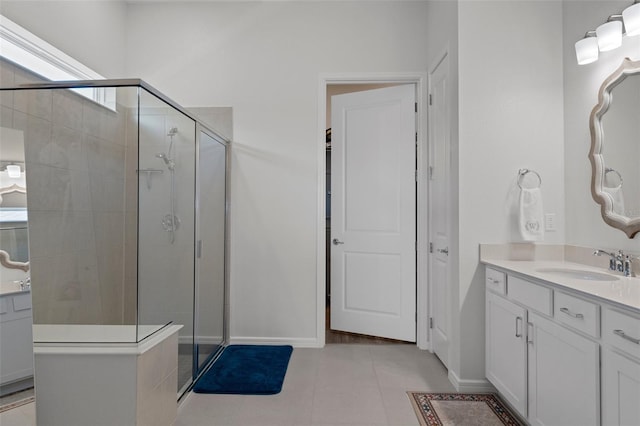 bathroom featuring tile patterned flooring, a shower stall, vanity, and baseboards