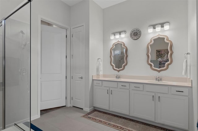 full bath featuring double vanity, tile patterned floors, a tile shower, and a sink