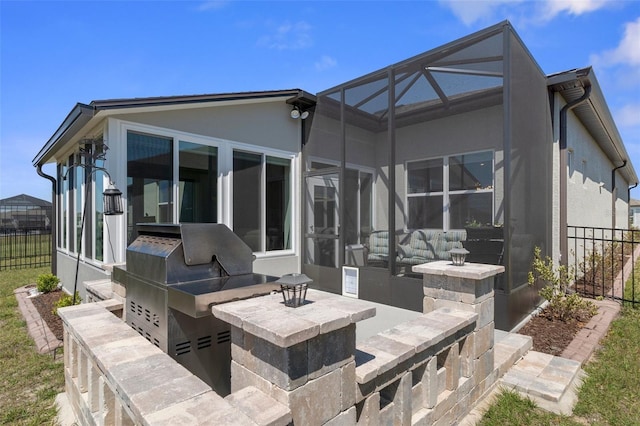 view of patio featuring a lanai, an outdoor kitchen, and fence