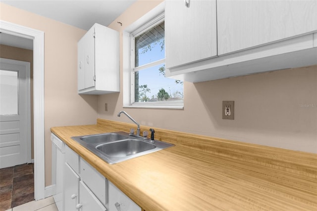 kitchen with white cabinetry, light countertops, dishwasher, and a sink