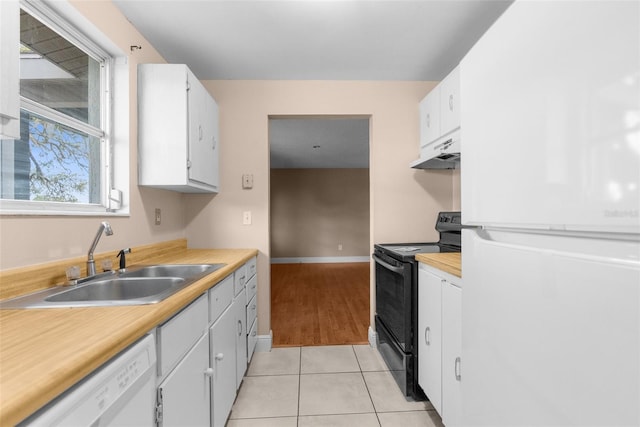 kitchen featuring white appliances, light tile patterned flooring, a sink, light countertops, and under cabinet range hood