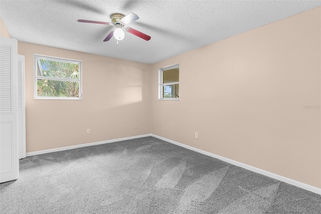 spare room featuring baseboards, carpet floors, and a textured ceiling