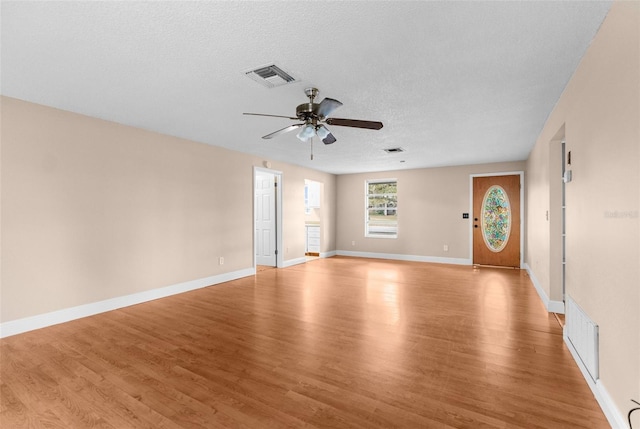 unfurnished living room with visible vents, ceiling fan, and light wood finished floors