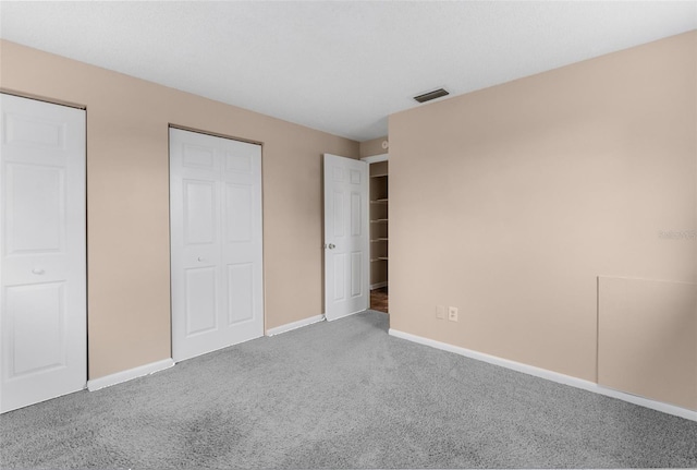 unfurnished bedroom featuring baseboards, visible vents, and carpet floors