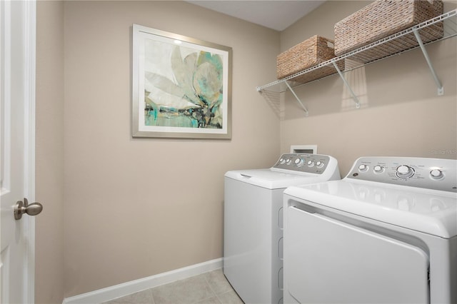 laundry room featuring light tile patterned floors, laundry area, baseboards, and separate washer and dryer