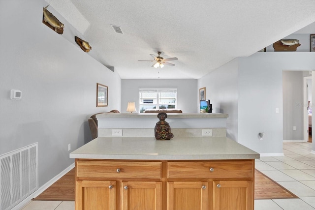 kitchen with light tile patterned floors, visible vents, and open floor plan