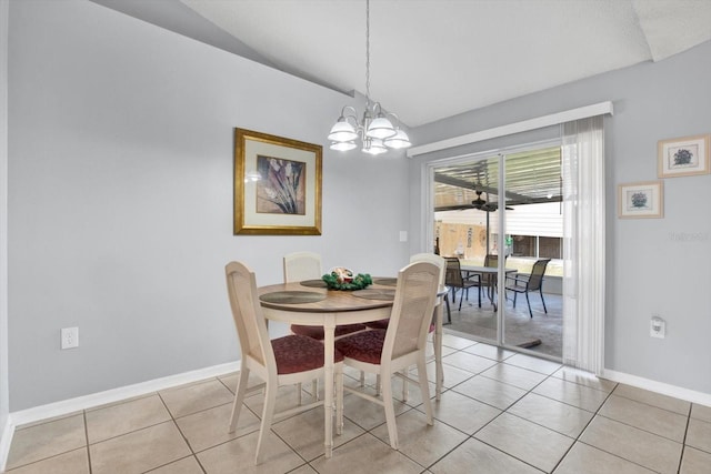 dining space featuring baseboards, a notable chandelier, light tile patterned flooring, and vaulted ceiling