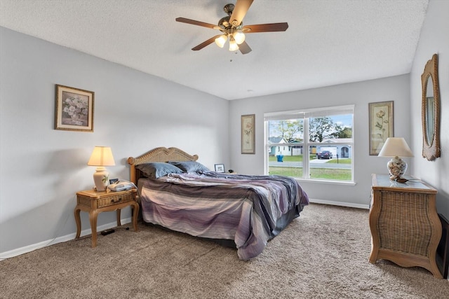 carpeted bedroom featuring baseboards, a textured ceiling, and a ceiling fan