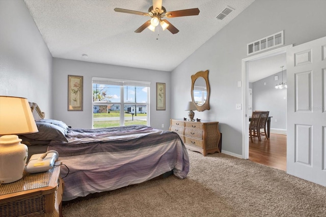 bedroom featuring visible vents, a textured ceiling, carpet, and vaulted ceiling