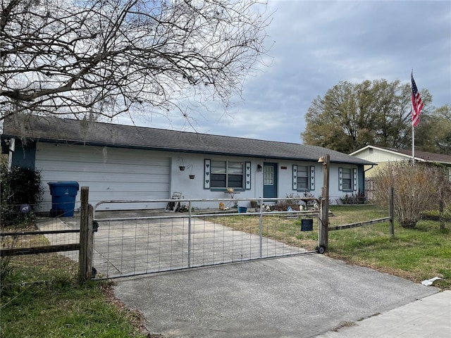 single story home with a fenced front yard, a garage, driveway, and a gate