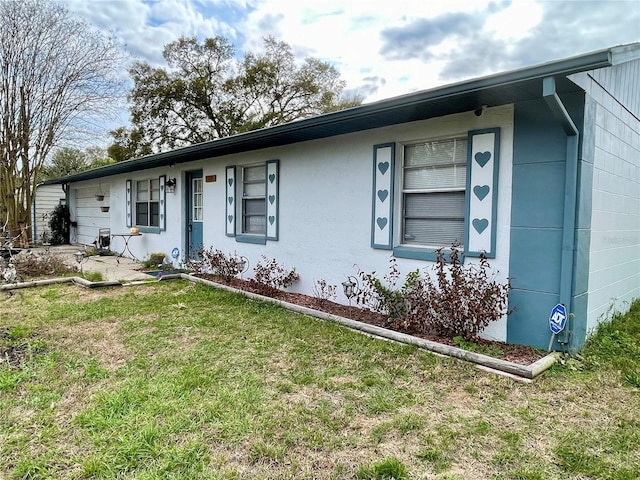 single story home with a front lawn and stucco siding