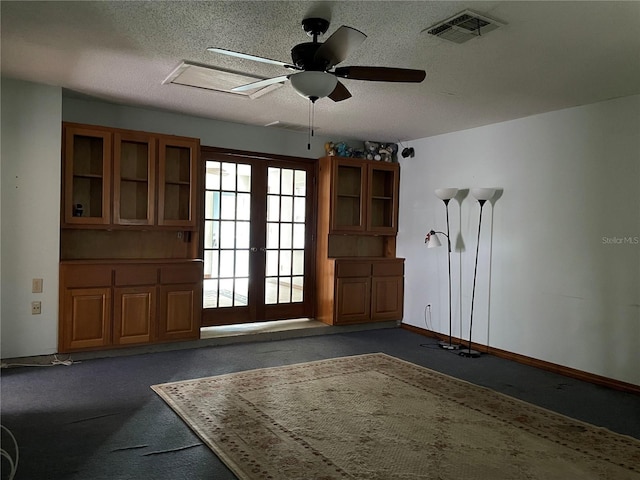 interior space featuring visible vents, french doors, a textured ceiling, and baseboards