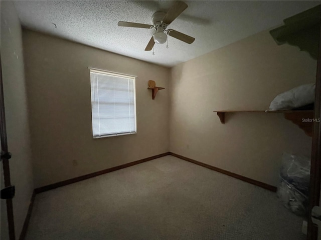 spare room featuring ceiling fan, light colored carpet, baseboards, and a textured ceiling