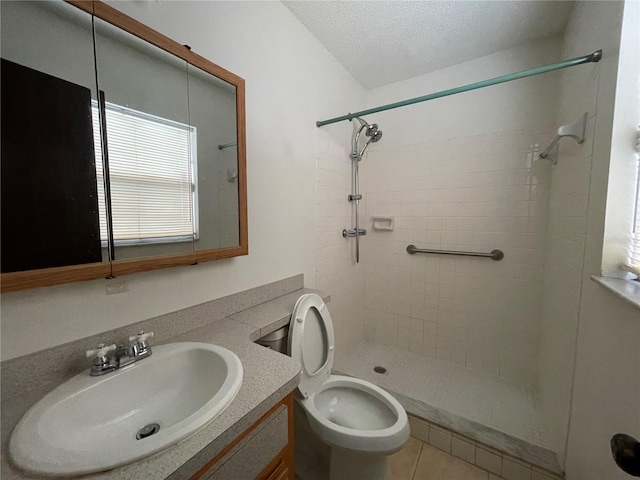 full bathroom with a textured ceiling, toilet, vanity, and tiled shower