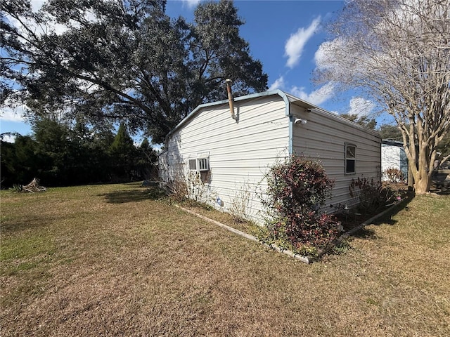 view of side of home with a lawn and a wall mounted air conditioner