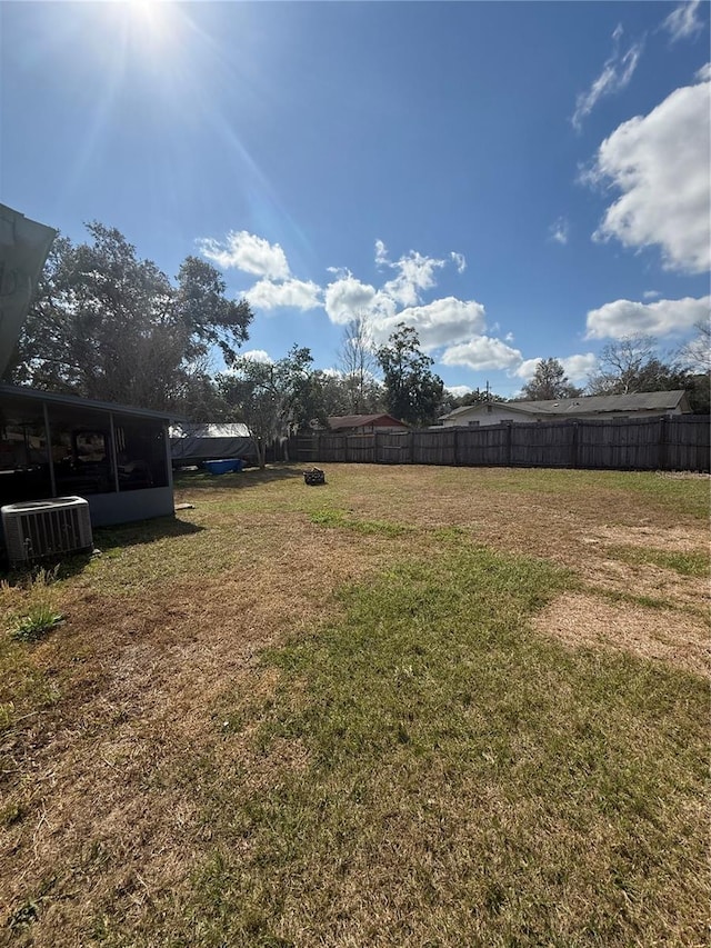 view of yard with fence and central AC