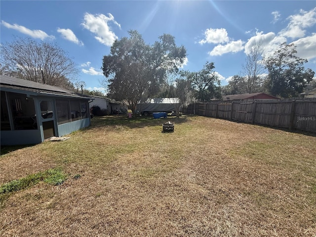 view of yard featuring a fenced backyard and a sunroom